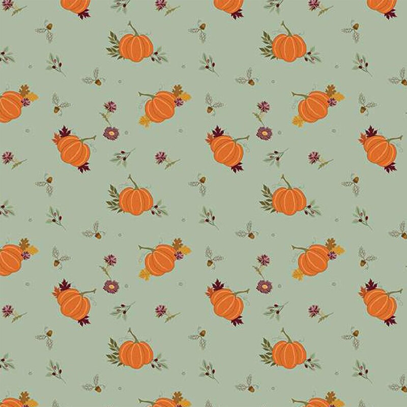 Fabric with orange pumpkins and small flowers on a soft teal background.