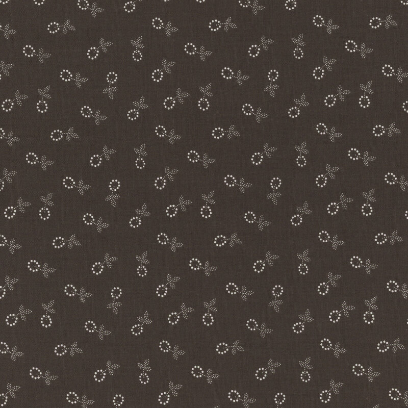 Fabric featuring a calico pattern of small off white flower blossoms on a dark brown background