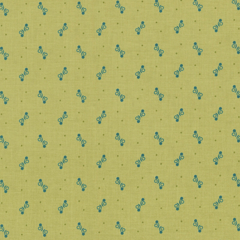 Fabric featuring small blue dotted shapes on a light green backdrop.