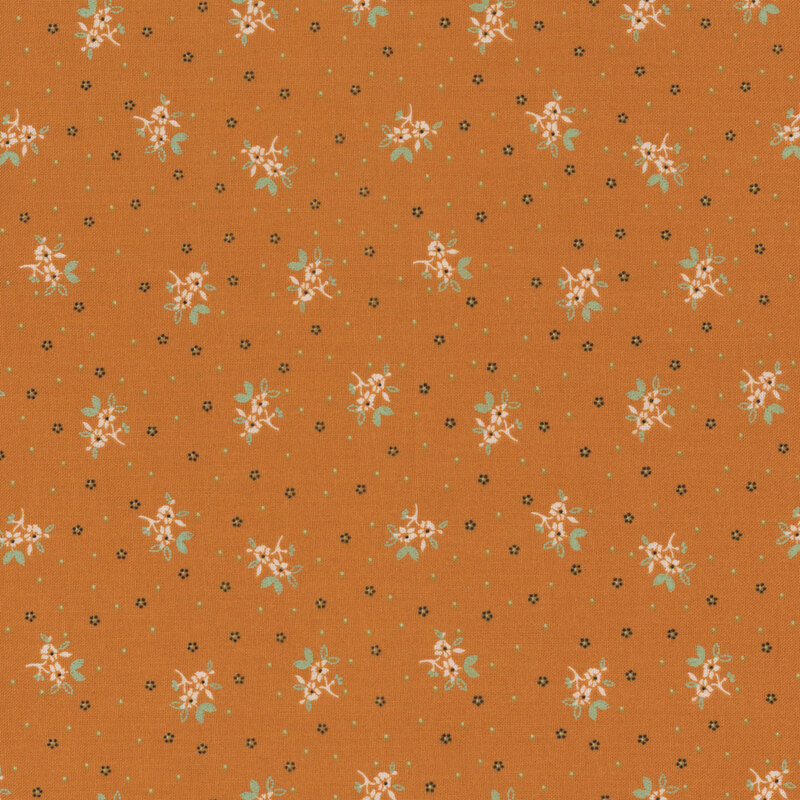A warm orange fabric background with scattered small white floral patterns and black dots.