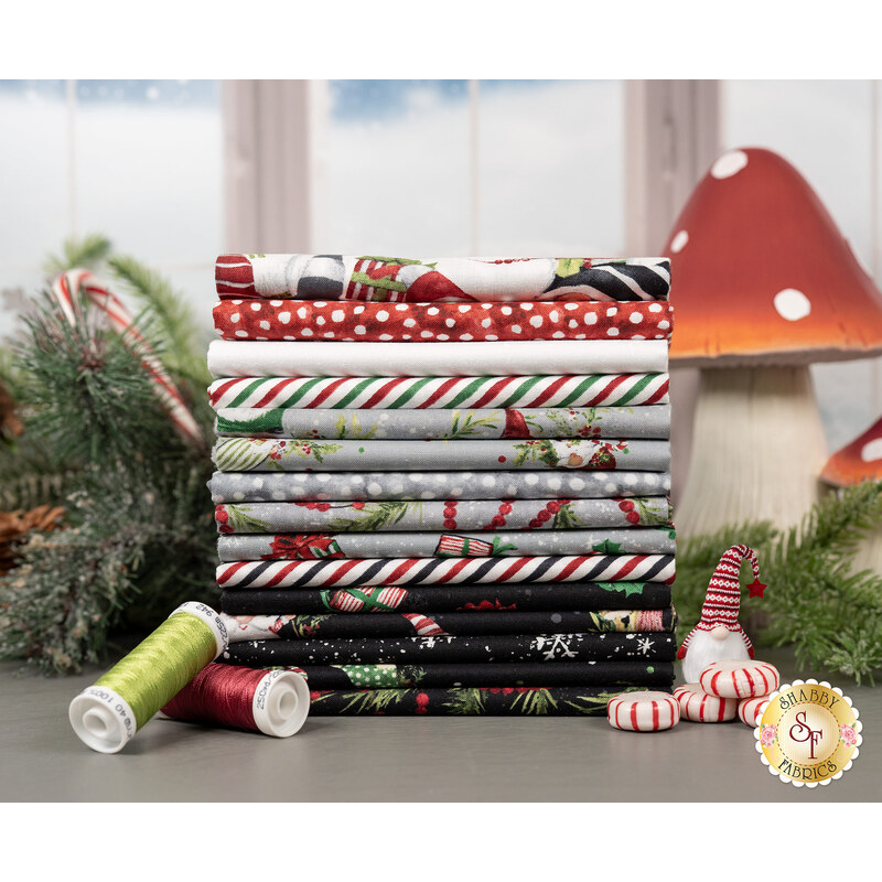 A stack of the Holiday Gnome-themed fabric from the Merry Gnome-ments FQ set, with mushrooms and pine branches and canycanes and thread, and a gnome.