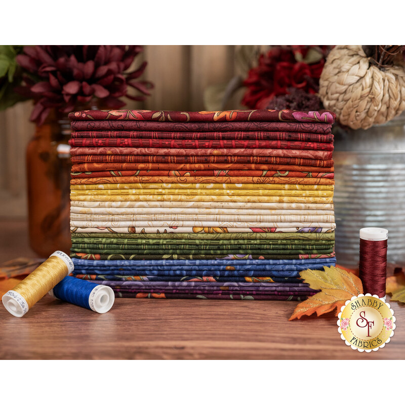 A stack of the fabrics included in the Autumn Breeze FQ set by Benartex, with flowers and a jar and leaves and thread and a jug.