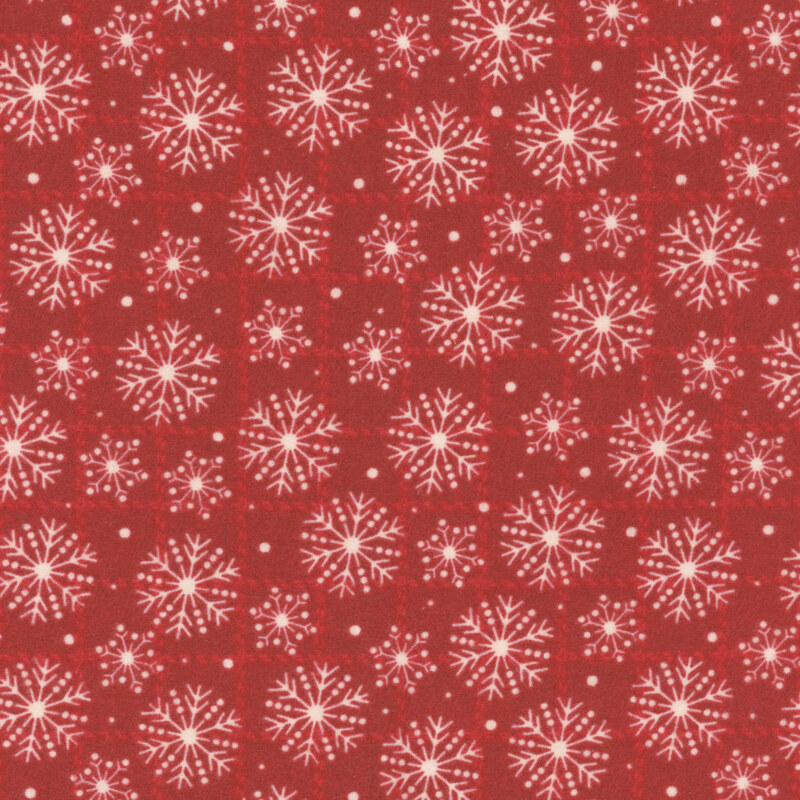 Red fabric featuring a repeated pattern of white snowflakes and small dots.