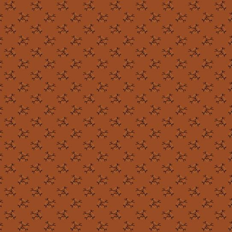 Burnt orange fabric with a unique pattern of black tree branches inside a frame of cream dots.