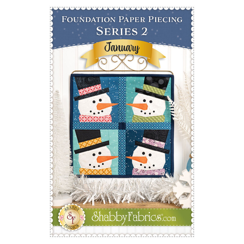 Front cover of the pattern showing the completed project in navy, aqua, and white fabrics, staged on a craft stand atop a rustic wood table top with coordinating holiday decor.