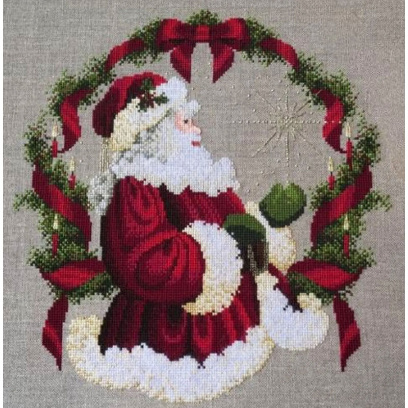 The completed The Spirit of Christmas cross stitch hung in an ornate wooden frame.