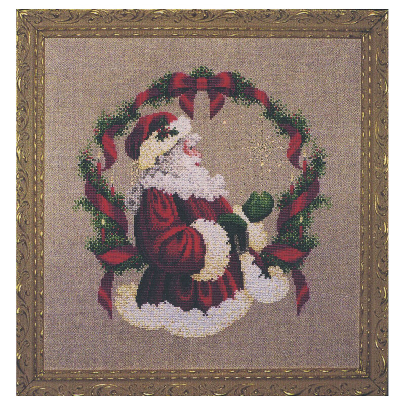 The completed The Spirit of Christmas cross stitch hung in an ornate wooden frame.