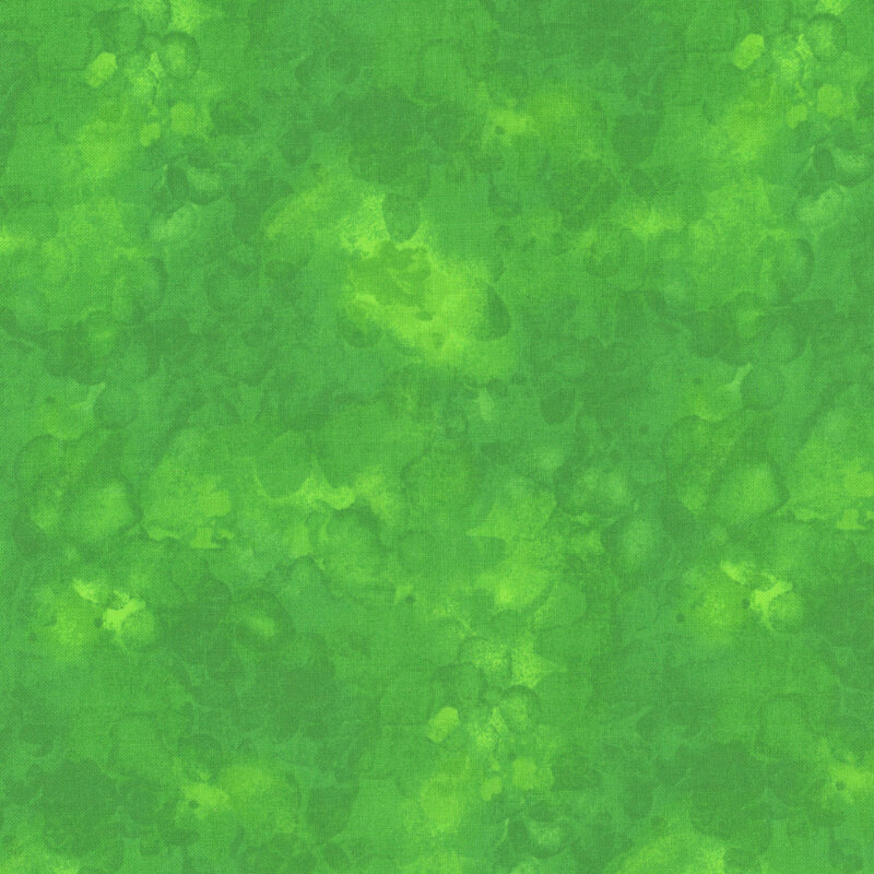 Abstract green fabric with varying shades, resembling a watercolor or marbled effect.
