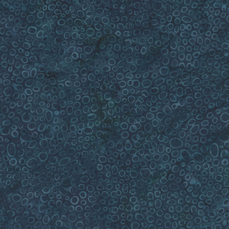 Dark blue abstract fabric with varying circular shapes and patterns throughout the surface.