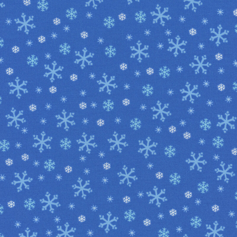 Medium blue fabric with tossed white, tonal blue, and cyan snowflake designs.