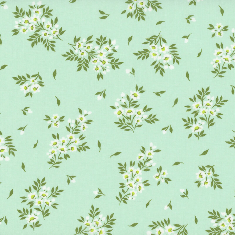 Fabric swatch of a light mint green background adorned with scattered white floral clusters and green leaves.