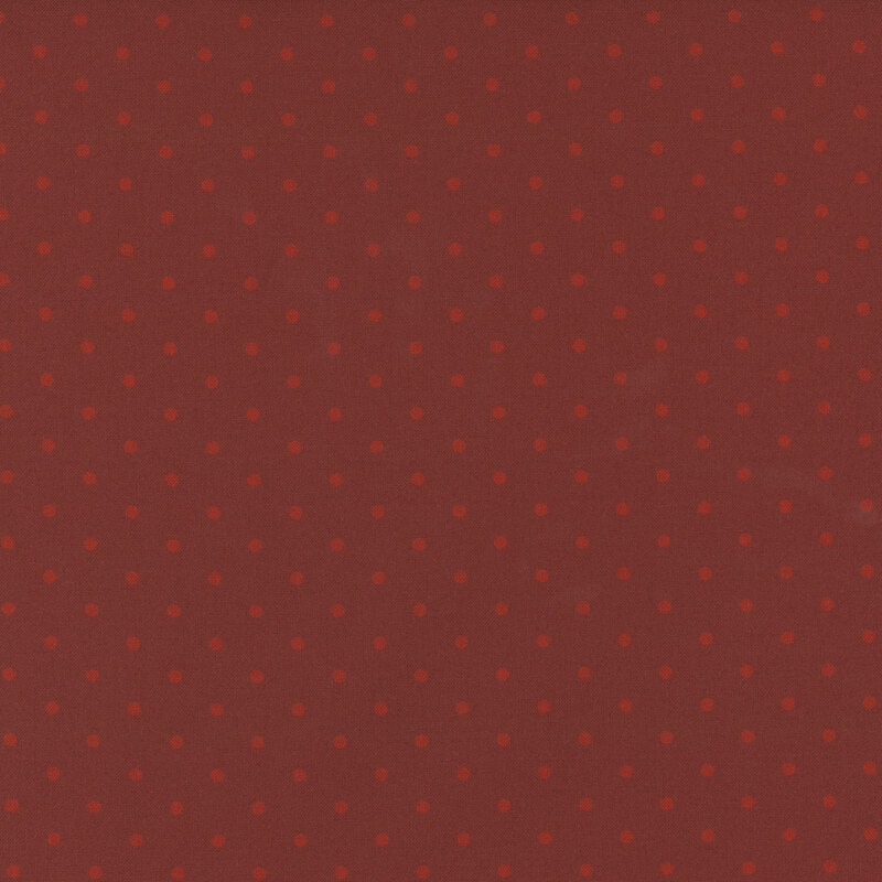 Red fabirc with a repetitive pattern of small, evenly spaced polka dots.