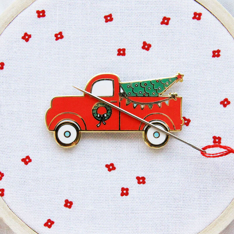 The Christmas truck needle minder displayed on a hand embroidery project.