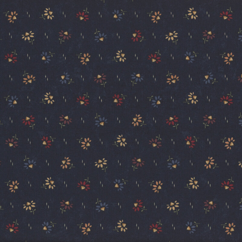 Small, colorful flowers scattered on a dark fabric background with a subtle texture.