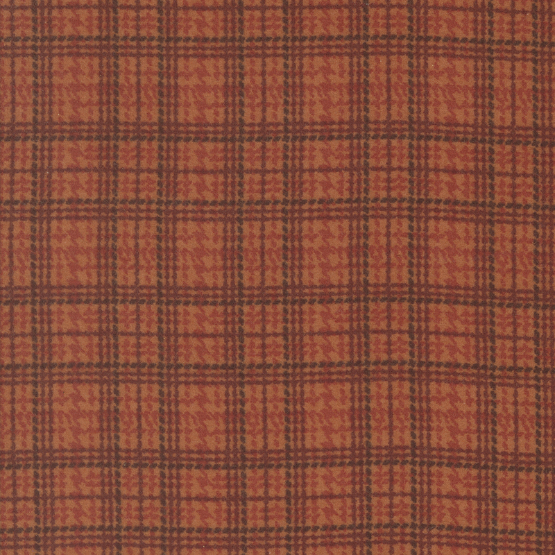 Close-up of a red and orange plaid fabric pattern with dark grid lines.