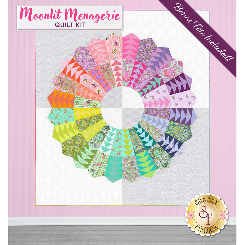 Colorful quilt pattern featuring a circular design with petals in vibrant hues against a light pink backdrop. A purple banner reads, 