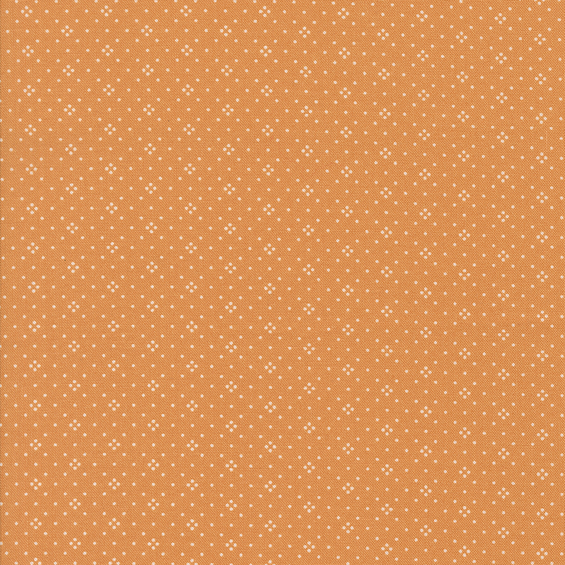 A orange fabric with a consistent pattern of small white dots.