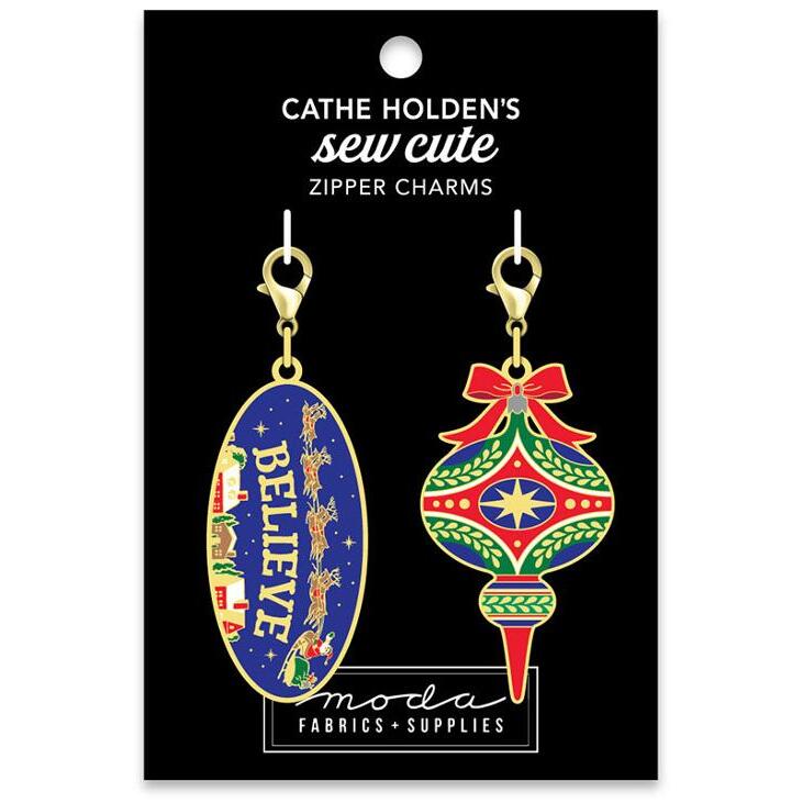 A black tag with a colorful Christmas ornament and a blue Believe zip pull.