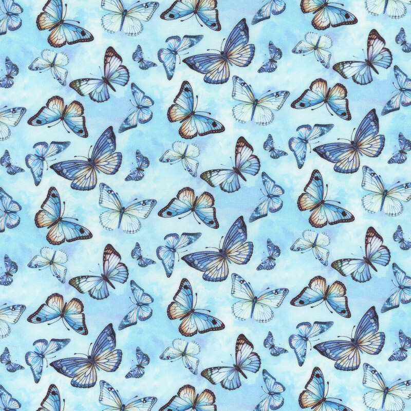 Blue fabric with different sized blue and yellow butterflies on a background with purple and light blue mottling.