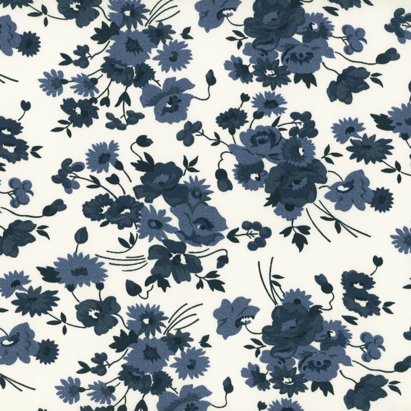 A fabric pattern featuring various blue flowers and navy leaves on a white background.