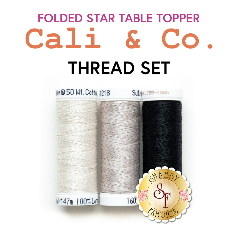 The Folded Star Table Topper - Cali & Co - 3pc Thread Set, a set of white, gray, and black spools of thread, isolated on a white background below a text graphic.