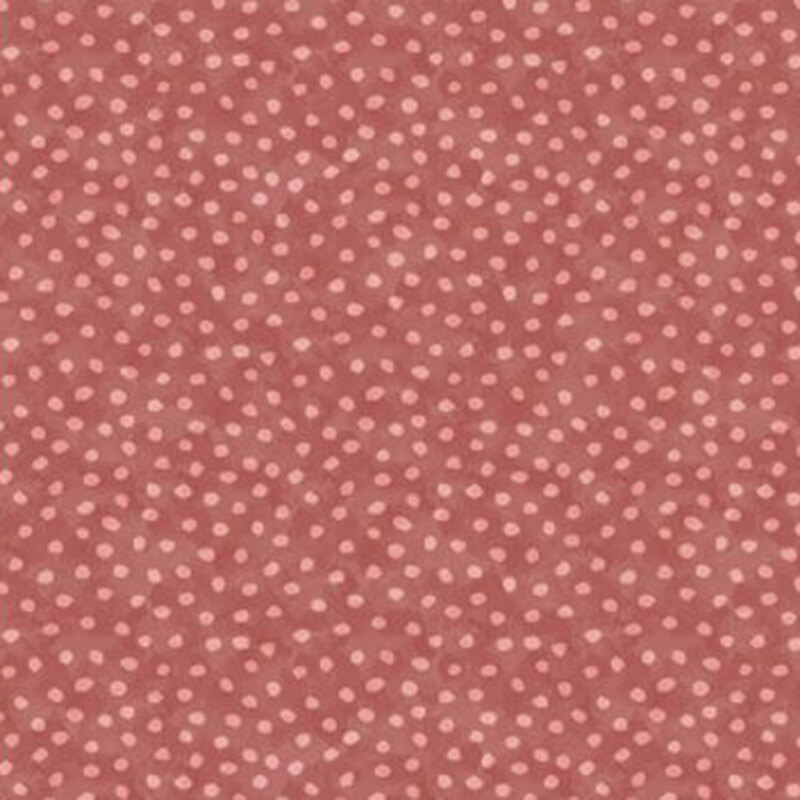 Fabirc of rust-colored fabric with small, light pink dots scattered throughout.