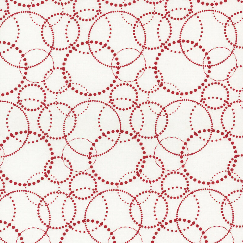 White fabric with overlapping red dotted circles in varying sizes.