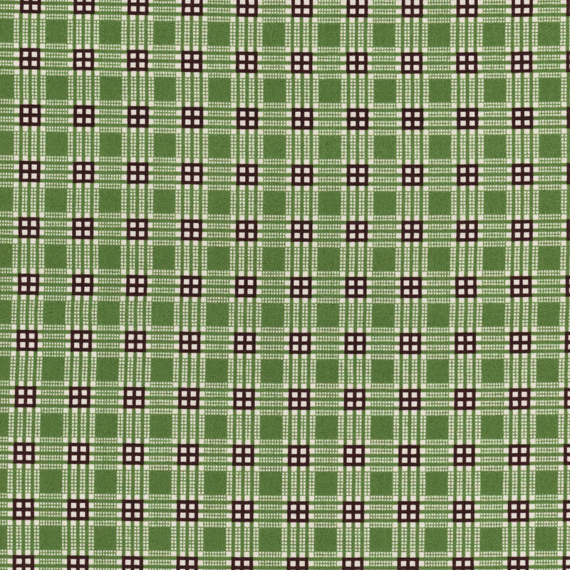 Green plaid fabric featuring black lines and white dots arranged in a grid format.