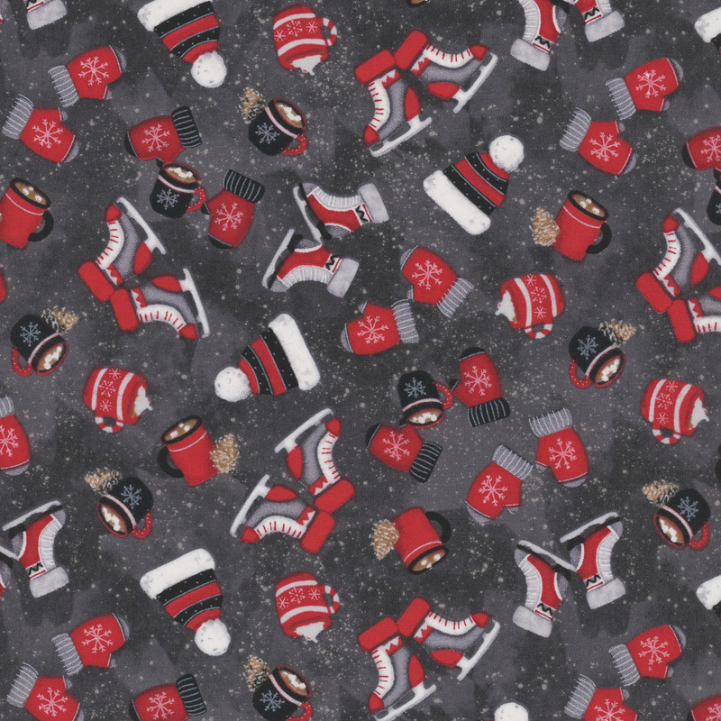 Dark gray fabric with tossed mittens, hot cocoa, hats, and ice skates on a paint-flecked background.