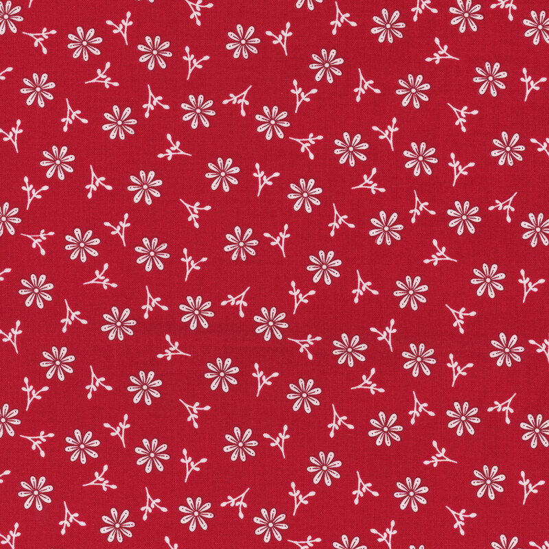 Fabric with various white flower shapes and small buds on a red background.