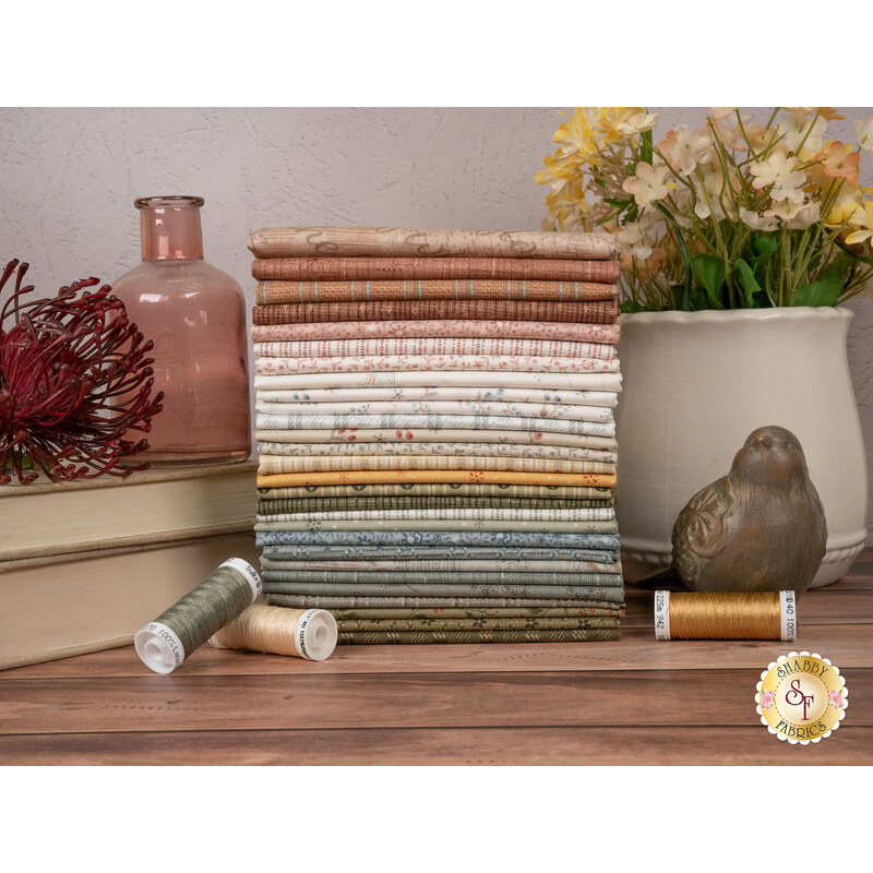 A stack of the fabrics included in the Simply Charming fabric collection, with flowers and a vase and a jar and books and bird and thread.