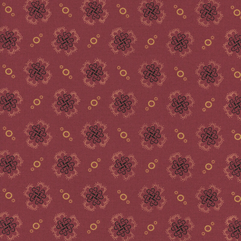 fabric pattern of golden threads of knots and circles on a red background