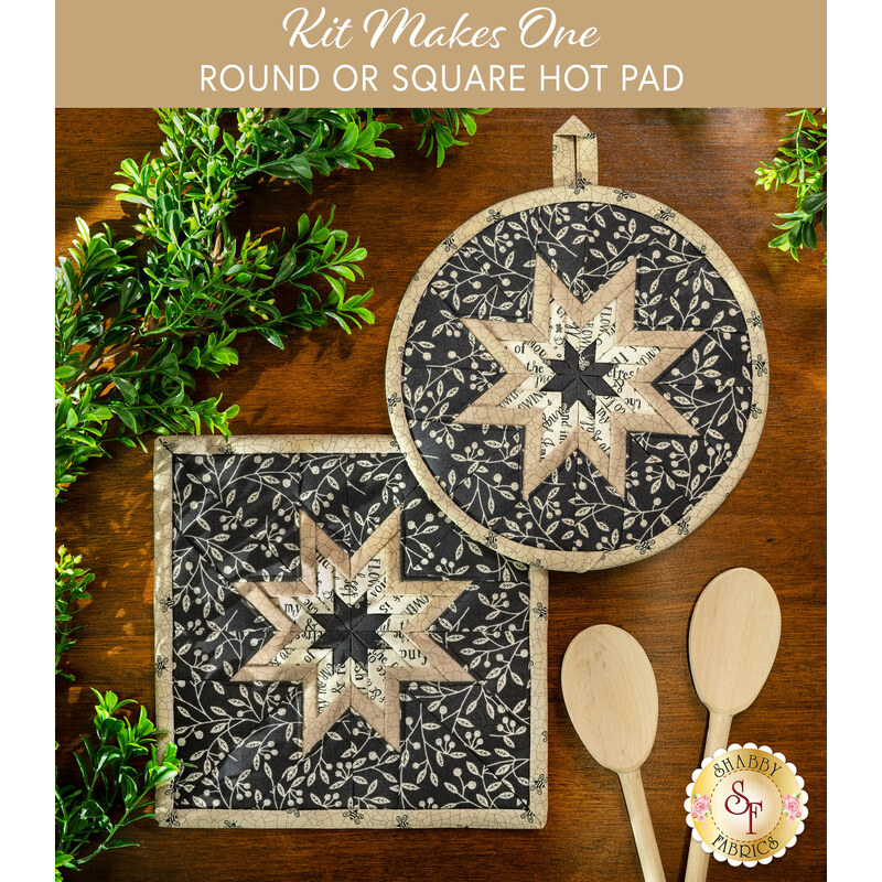 The two completed Black Folded Star Hot Pads, one round and one square, slightly overlapping each other and staged on a rustic table with greenery and wooden spoons.