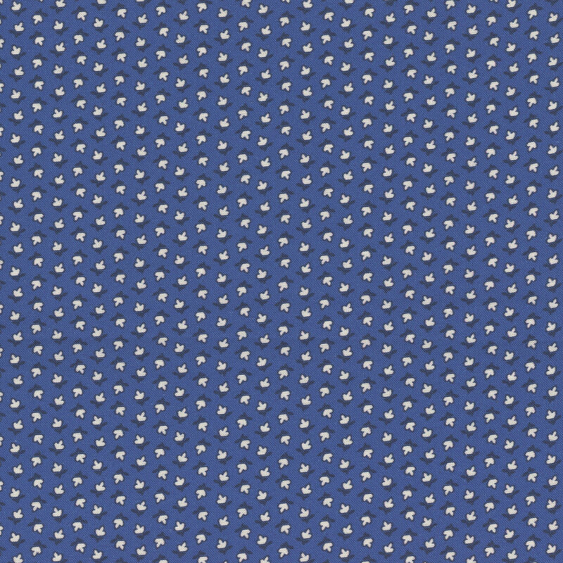 fabric pattern of white floral motifs on a blue background