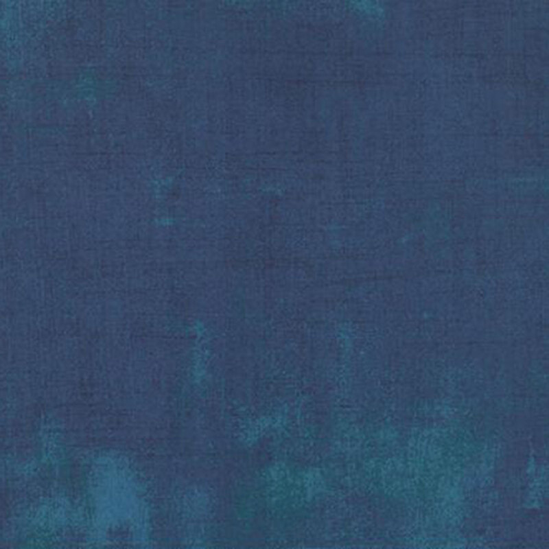 Textured fabric in shades of deep blue with a subtle gradient and uneven coloration.