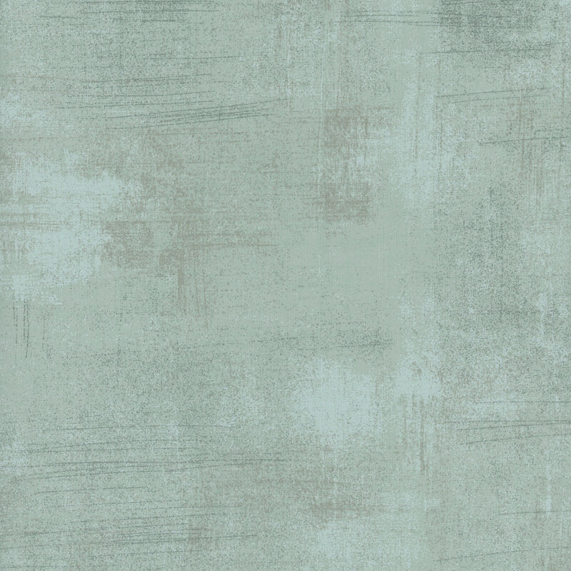 Light gray textured fabric with subtle variations and faint lines.