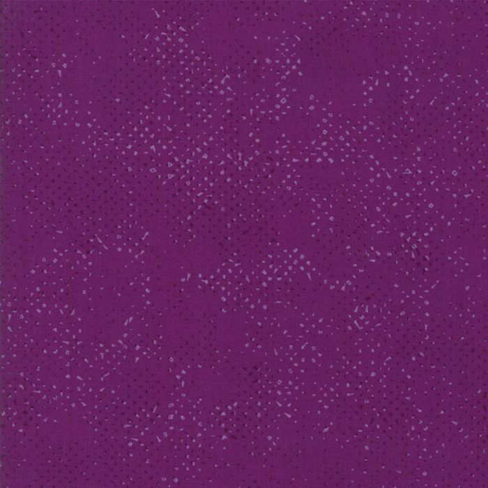 Textured magenta purple fabric with a pattern of small tonal speckles