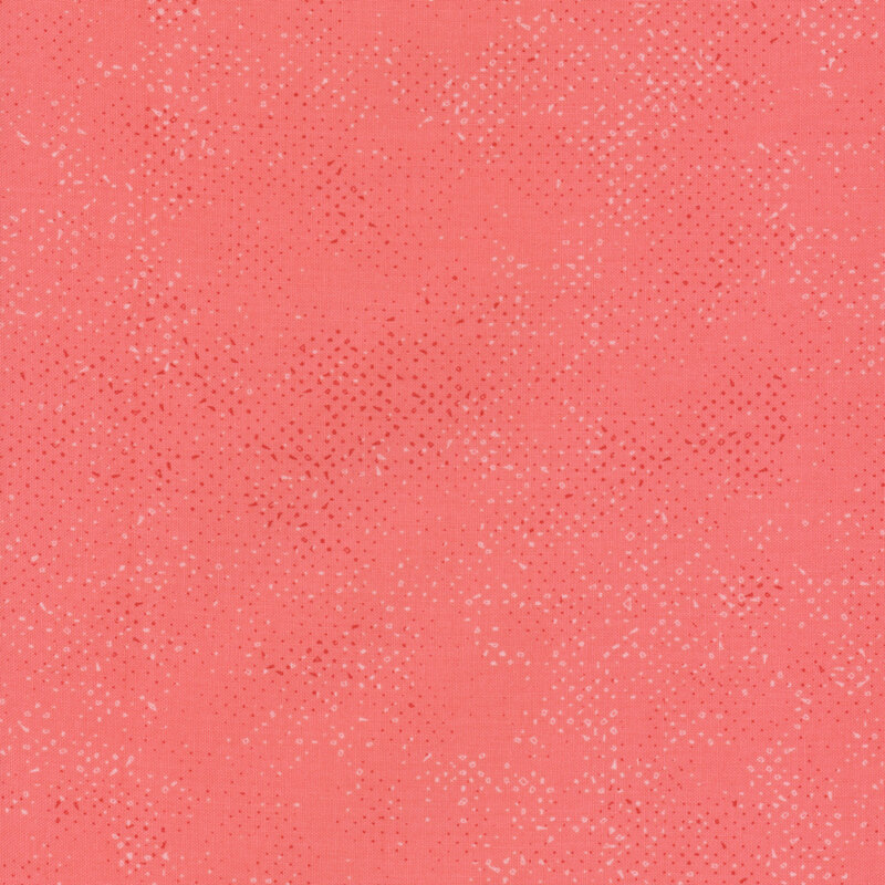 Textured coral pink fabric with a pattern of small tonal speckles