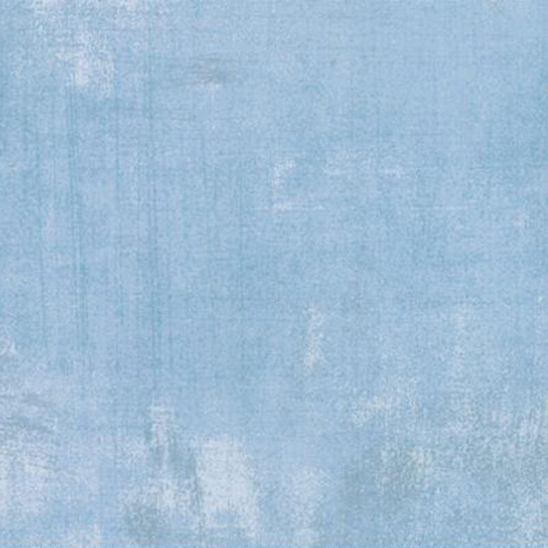 Light blue textured fabric with subtle variations and brushstroke patterns.