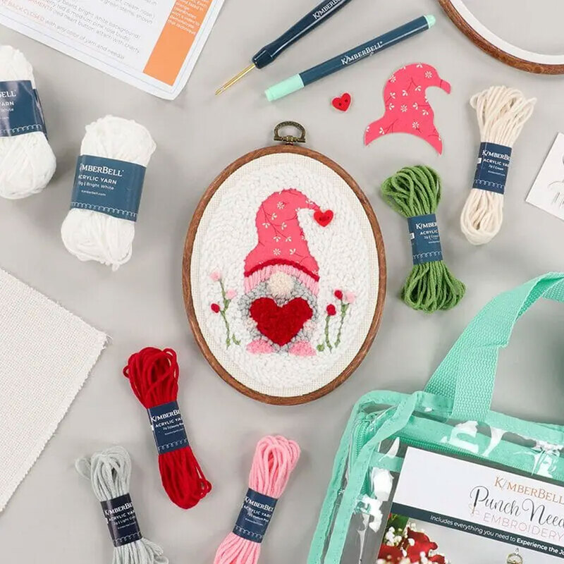 Embroidery hoop featuring a valentine gnome, surrounded by crafting supplies.