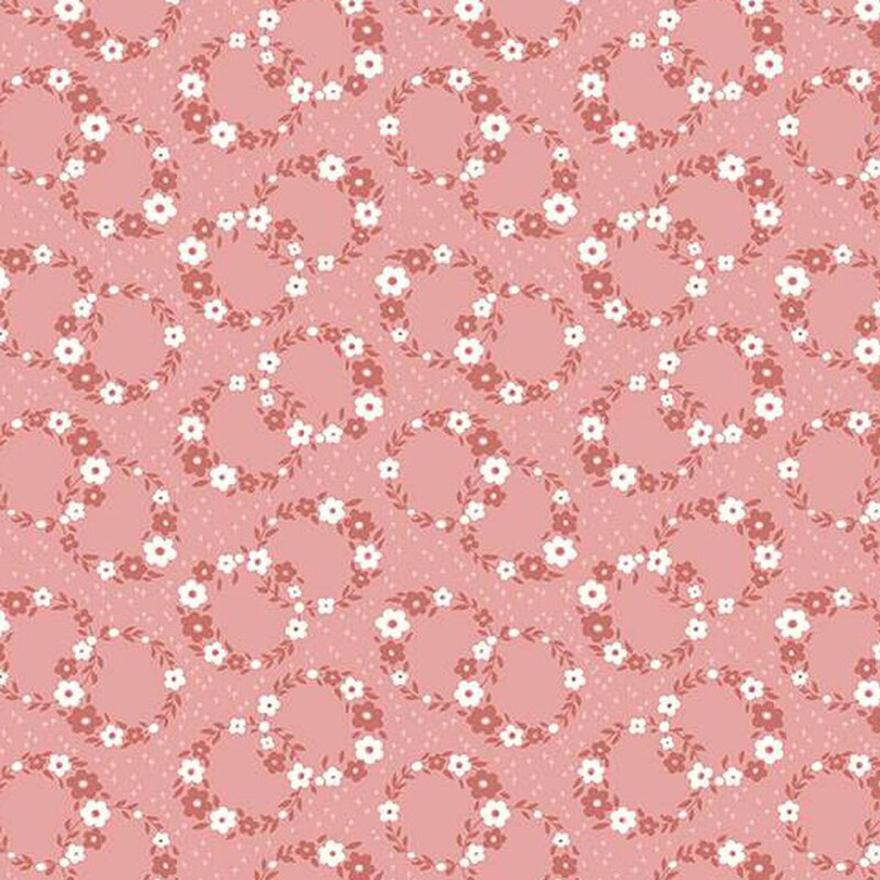 fabric pattern of floral wreaths in a calico pattern over a pink background