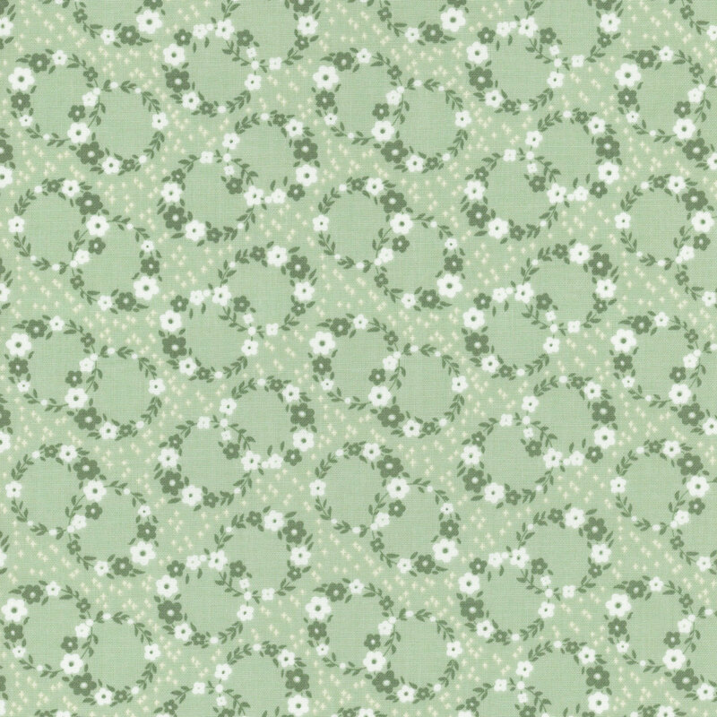 Mint green fabric with a calico pattern of floral wreaths overlapping.