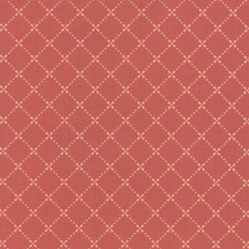 Rusty pink fabric with a dotted lattice pattern in light pink.