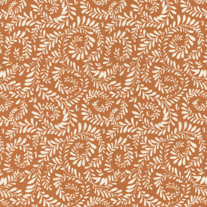 Burnt orange fabric with vines curled in a swirling pattern.