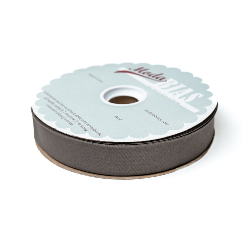 Spool of dark gray bias tape isolated on a white background