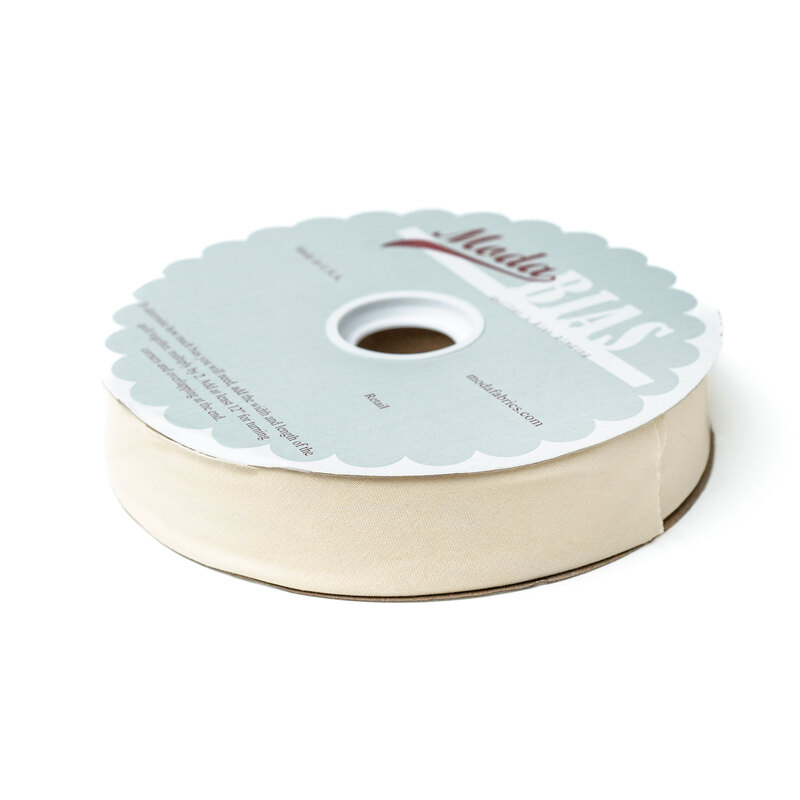 Spool of cream bias tape isolated on a white background