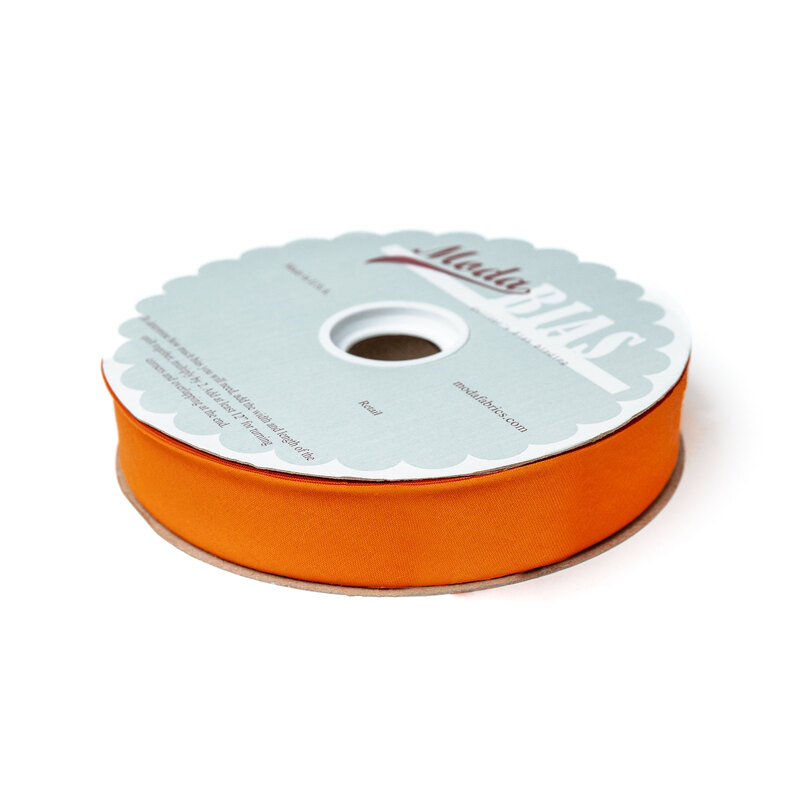 Spool of orange bias tape isolated on a white background