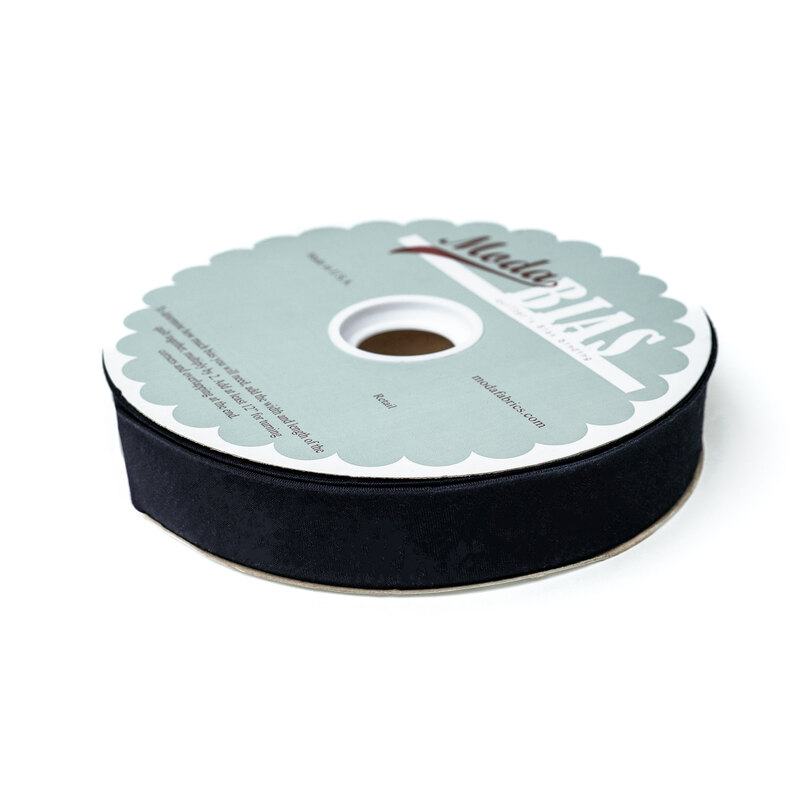 Spool of navy blue bias tape isolated on a white background