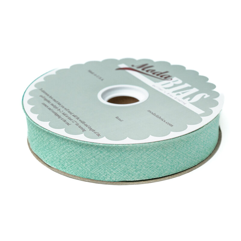 Spool of seafoam bias tape isolated on a white background