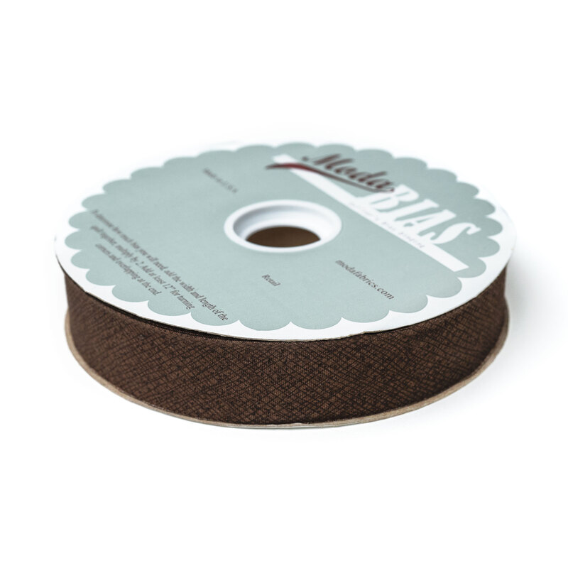 Spool of chocolate brown bias tape isolated on a white background